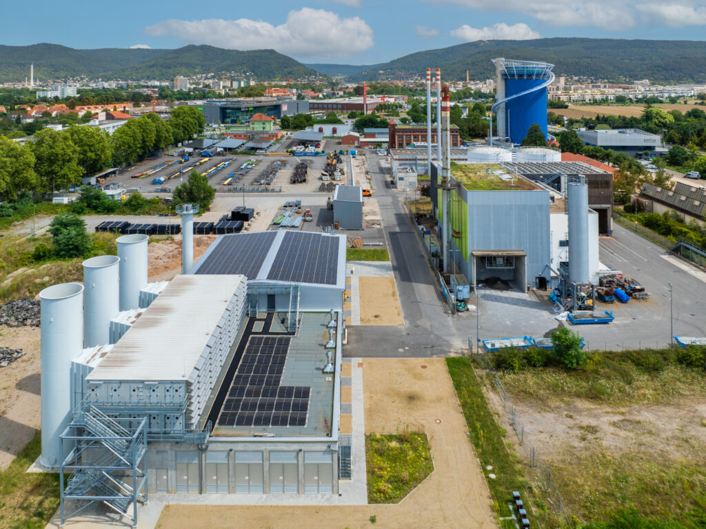 Eine große Industrieanlage mit Solarpanelen auf dem Dach.
