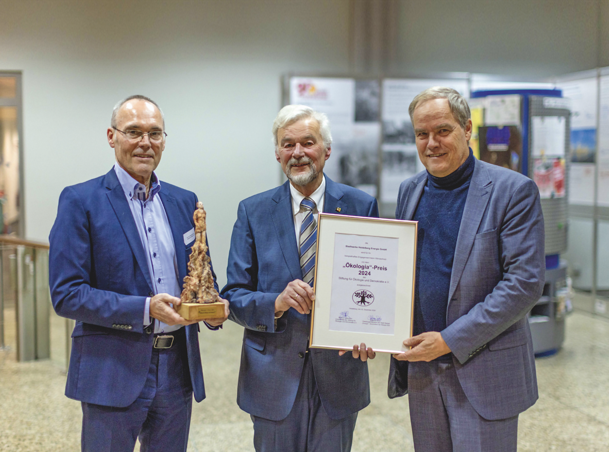 Drei Männer in Anzügen halten eine Auszeichnung sowie die Ökologia-Skulptur , überreicht von Hans-Joachim Ritter an Prof. Dr. Eckart Würzner und Prof. Dr. Rudolf Irmscher.