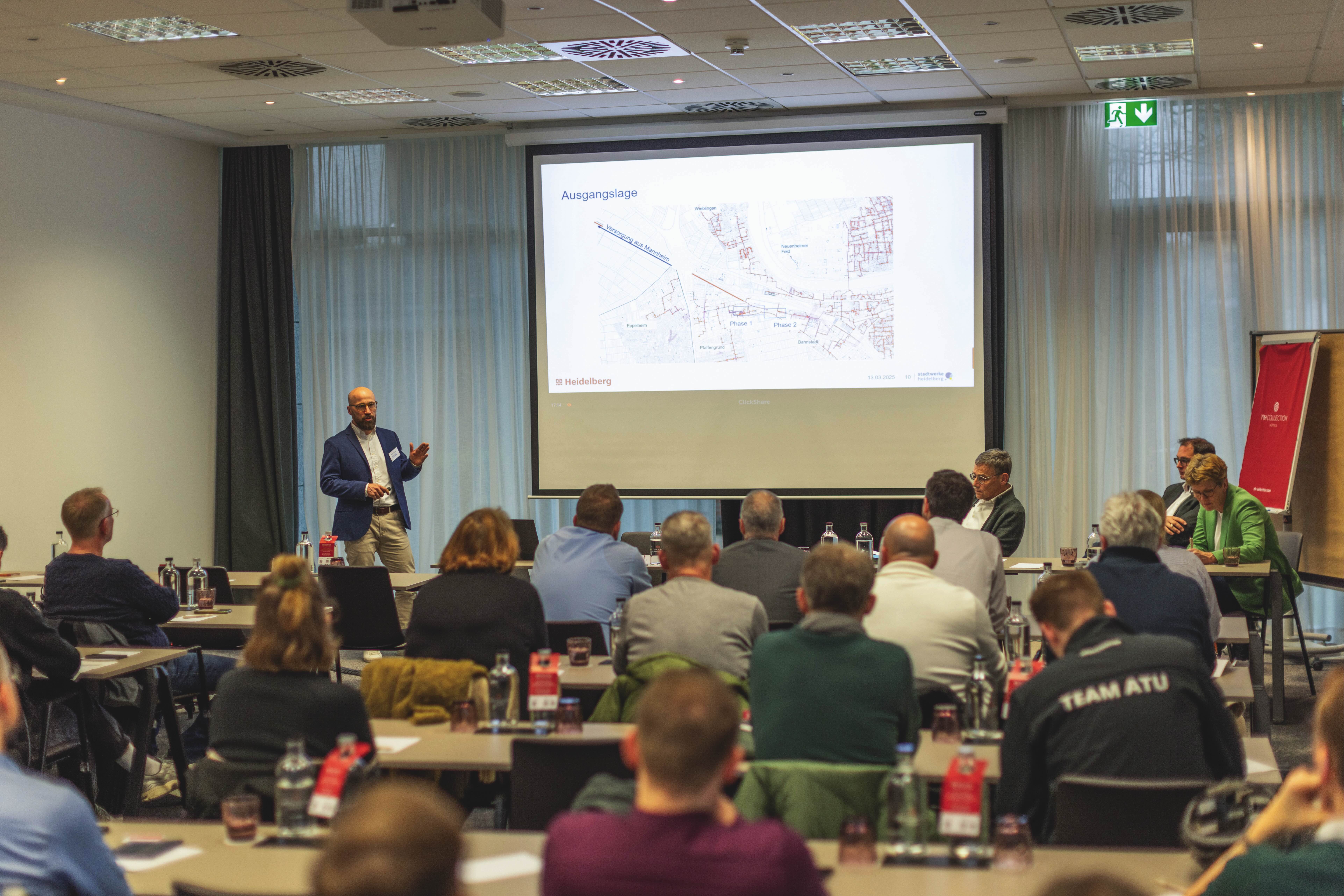 Präsentation im Seminarraum mit Teilnehmern, Vortragender präsentiert eine Karte