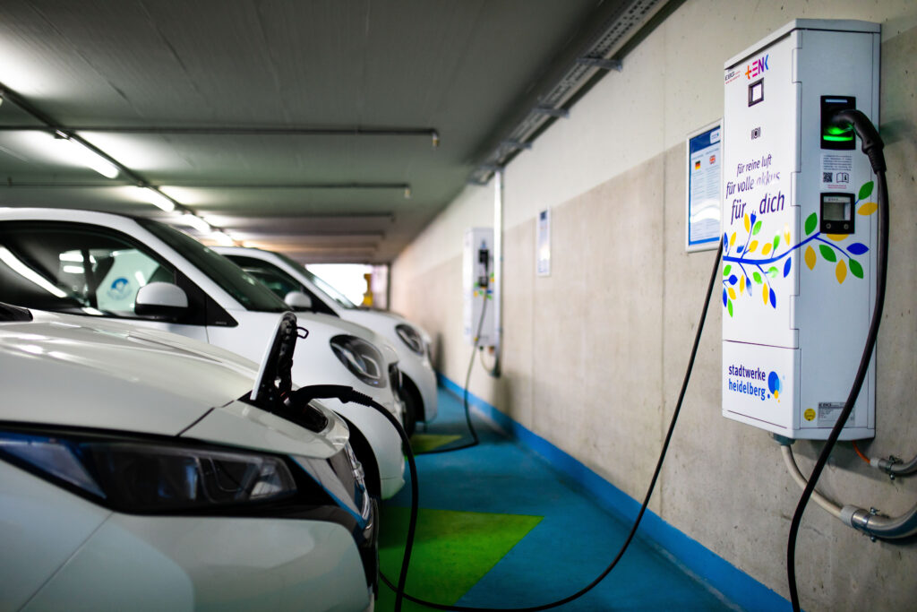 Elektroautos an Ladestationen in einer Tiefgarage, Ladekabel verbunden, Ladestation mit Aufschrift 'für mehr Mut, für mehr dich' der Stadtwerke Heidelberg