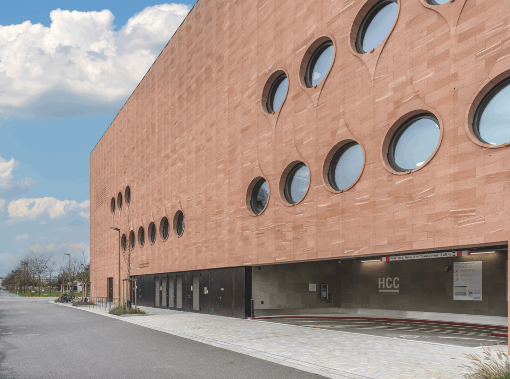 Neues Parkhaus P21 am Heidelberg Congress Center mit runden Fenstern und rotem Sandsteinfassade in Heidelberg-Bahnstadt